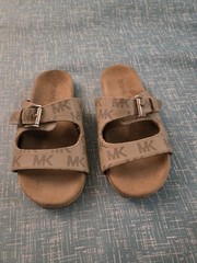 Michael Kors buckle slides featuring a signature logo monogram pattern