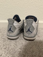 White and navy blue Air Jordan 4 sneakers with gray accents.