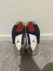 White and navy blue Air Jordan 4 sneakers with gray accents.