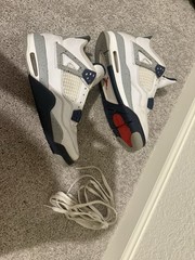 White and navy blue Air Jordan 4 sneakers with gray accents.