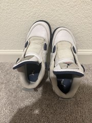White and navy blue Air Jordan 4 sneakers with gray accents.
